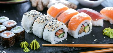 Suşi Sashimi ve suşi ruloları taş levhada servis edilir.