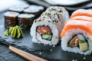 Suşi Sashimi ve suşi ruloları taş levhada servis edilir.