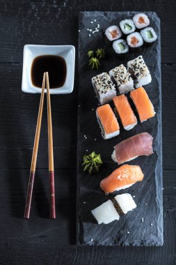 Suşi Sashimi ve suşi ruloları taş levhada servis edilir.