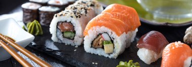 Suşi Sashimi ve suşi ruloları taş levhada servis edilir.