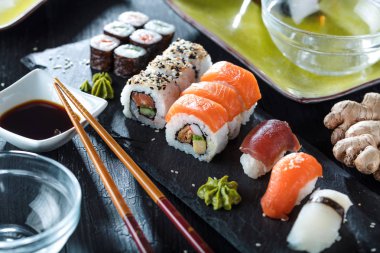 Suşi Sashimi ve suşi ruloları taş levhada servis edilir.