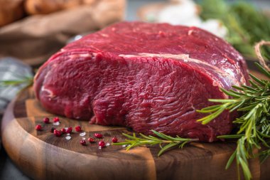 Koyu ahşap masada çiğ biftek..