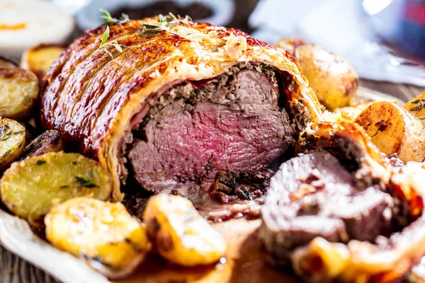 Beef Wellington, classic steak dish on rustic wooden table