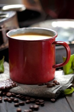 kahve fincanı ve masada kahve çekirdekleri