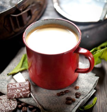 kahve fincanı ve masada kahve çekirdekleri