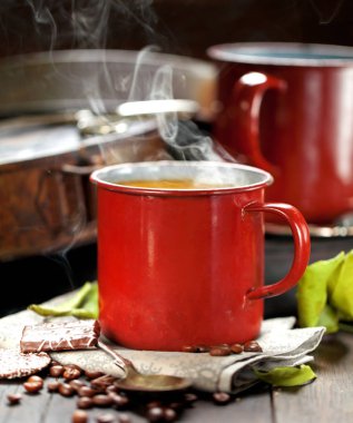 kahve fincanı ve masada kahve çekirdekleri