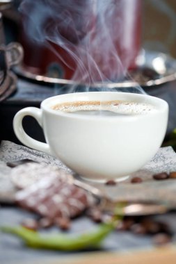 kahve fincanı ve masada kahve çekirdekleri