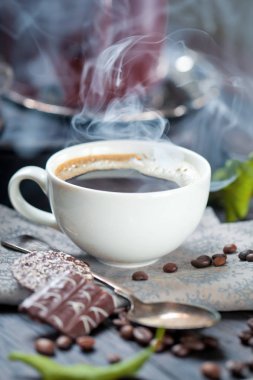 kahve fincanı ve masada kahve çekirdekleri