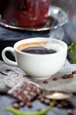 kahve fincanı ve masada kahve çekirdekleri