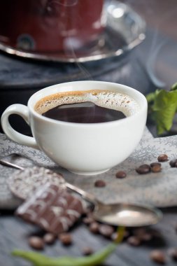 kahve fincanı ve masada kahve çekirdekleri