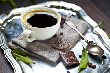 kahve fincanı ve masada kahve çekirdekleri
