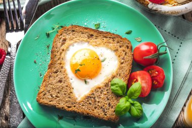 Sevgililer günü - kızarmış yumurta ve ekmek taze sebze ve bir kalp şeklinde Servis Kahvaltı.