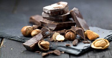 bir tablo üzerinde bir parça çikolata içine dökülen erimiş çikolata