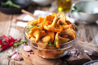 Sarı mantar Cantharellus cibarius karanlık mutfak masasının üzerinde orman bitkileri ile vintage plaka 