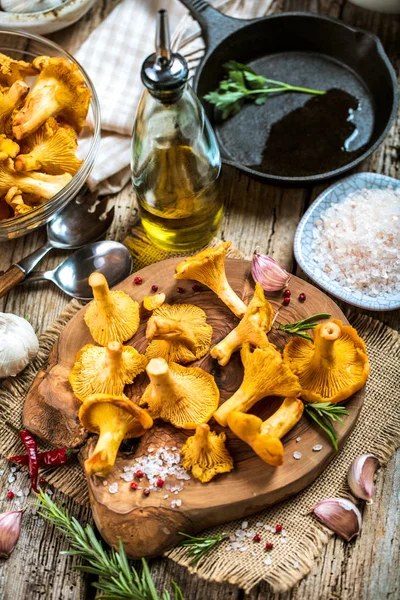 Yellow mushrooms chanterelle in vintage plate with forest plants on dark kitchen table