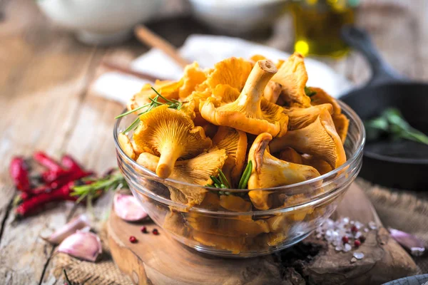 Sarı mantar Cantharellus cibarius karanlık mutfak masasının üzerinde orman bitkileri ile vintage plaka 