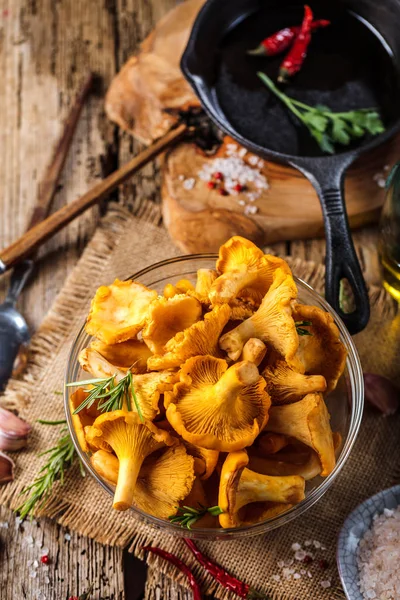 Yellow mushrooms chanterelle in vintage plate with forest plants on dark kitchen table