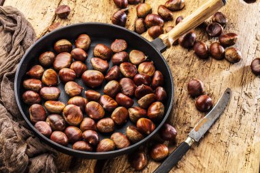 Eski bir tablo üzerinde kestane tavada kavrulmuş kestane hizmet