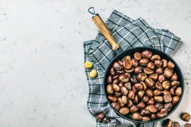 Eski bir tablo üzerinde kestane tavada kavrulmuş kestane hizmet