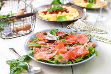 Parma ham jamon, domates ve plaka üzerinde roka salatası