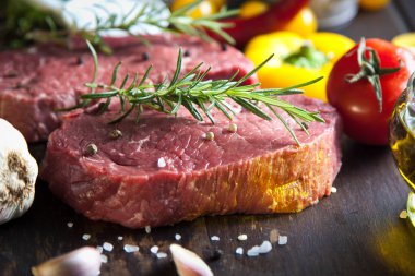 Koyu ahşap masada çiğ biftek..