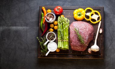 Koyu ahşap masada çiğ biftek..