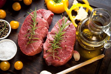 Koyu ahşap masada çiğ biftek..