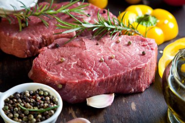 Koyu ahşap masada çiğ biftek..