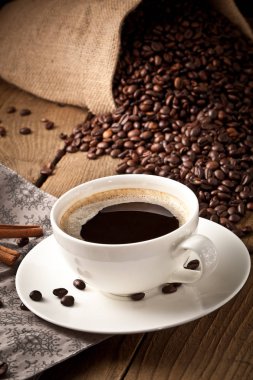 fincan kahve ve kek üzerine kahve çekirdekleri.