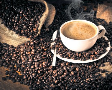 fincan kahve ve kek üzerine kahve çekirdekleri.