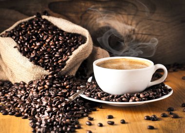 fincan kahve ve kek üzerine kahve çekirdekleri.