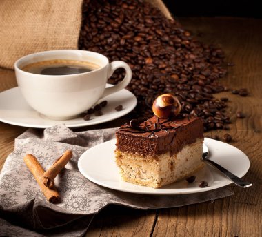 fincan kahve ve kek üzerine kahve çekirdekleri.