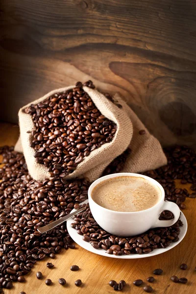 cup of coffee and  cake on coffee beans.