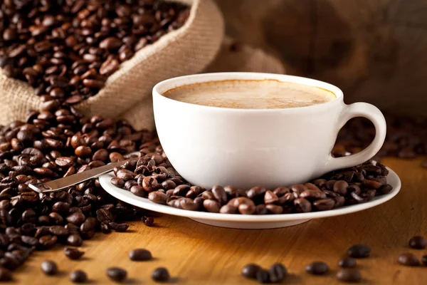 cup of coffee and  cake on coffee beans.