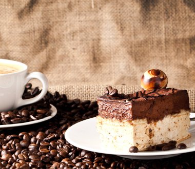 fincan kahve ve kek üzerine kahve çekirdekleri.