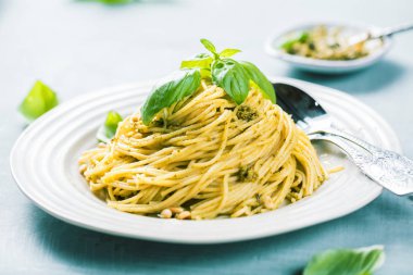 Fesleğen krem ve peynirli makarna spagetti. Üstten görünüm gri taş masada. Sebze vejetaryen makarna.