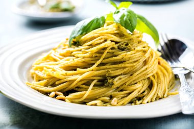 Fesleğen krem ve peynirli makarna spagetti. Üstten görünüm gri taş masada. Sebze vejetaryen makarna.