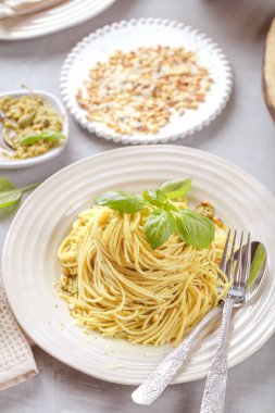 Fesleğen krem ve peynirli makarna spagetti. Üstten görünüm gri taş masada. Sebze vejetaryen makarna.