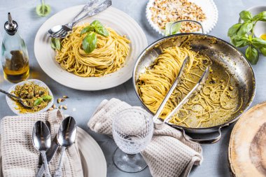 Fesleğen krem ve peynirli makarna spagetti. Üstten görünüm gri taş masada. Sebze vejetaryen makarna.