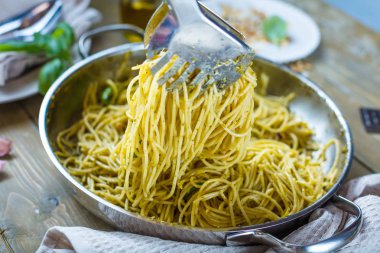 Fesleğen krem ve peynirli makarna spagetti. Üstten görünüm gri taş masada. Sebze vejetaryen makarna.