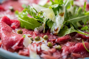 Dana carpaccio hardal ve parmesan ile siyah plaka üzerinde