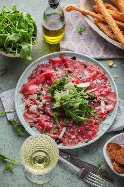 Dana carpaccio hardal ve parmesan ile siyah plaka üzerinde