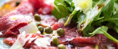 Dana carpaccio hardal ve parmesan ile siyah plaka üzerinde