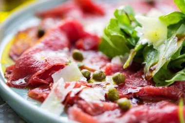 Dana carpaccio hardal ve parmesan ile siyah plaka üzerinde