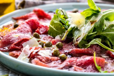 Dana carpaccio hardal ve parmesan ile siyah plaka üzerinde