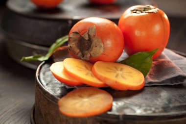 Lezzetli çiğ olgun hurma meyve karanlık paslı metal zemin üzerine alan en iyi görünüm Kopyala.