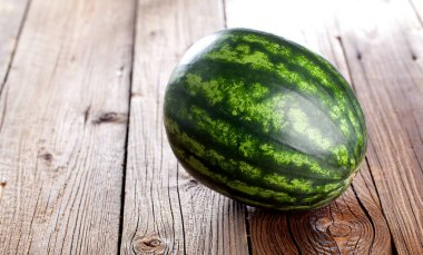 Ahşap zemin üzerinde taze çizgili dilimlenmiş karpuz.