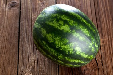 Ahşap zemin üzerinde taze çizgili dilimlenmiş karpuz.