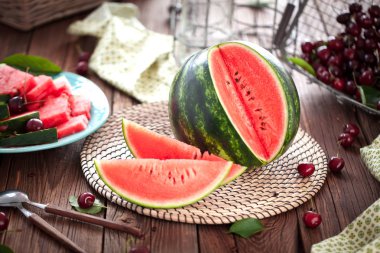 Ahşap zemin üzerinde taze çizgili dilimlenmiş karpuz.