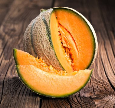 Karpuz kavun dilimleri ve eski ahşap bir masa yapraklarda. Organik gıda